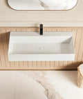 HAOCHRYSYPH Wall Mount Sink, Solid Surface, Matte White, 36 x 18 in. Top view of rectangular sink with black faucet.