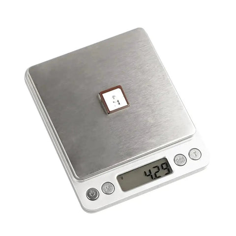 Drone GPS Module With M10 GNSS And QMC5883 Compass Ceramic Antenna on digital scale displaying 42.9 grams