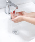 Hands washing over sink with Bathroom Sink Stopper For 1.1 To 1.5 Inch Drains, Bullet Core Push Type Pop Up Basin Drain Filter visible