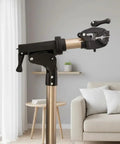 Foldable Aluminum Bike Repair Stand With Height Adjustable Arm in living room, showing clamp and metallic finish.