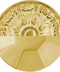 Close-up of a decorative solid core cabinet pull in brushed golden brass finish, showcasing intricate design.