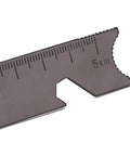 Close-up of multi function scraper from Grab And Go Emergency Fire Starter Kit with measurement markings, serrated edge visible.
