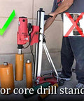 Side view of red core drill mounted on a portable wheeled stand with three orange core bits nearby.