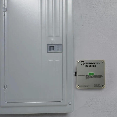 Advanced Outdoor Surge Protector With TPMOV Technology mounted on gray wall beside electrical panel, beefed up green status LED