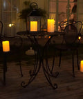 Outdoor Flameless Candles 8 by 4 Inch Waterproof Pillar Set of 2 with Remote Control illuminating a porch table.