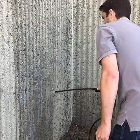 Person applying Straight Fire Block Sealer 1 Gallon Clear Penetrating Silane Siloxane Formula on textured concrete wall.