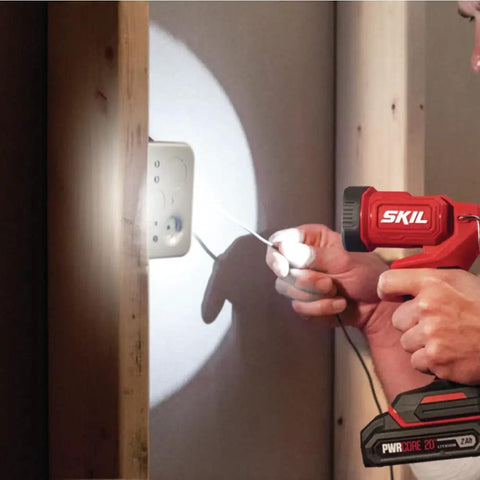Person using Ultra Bright Led Work Spotlight Rechargeable 20 Volt Cordless 300 Lumens Portable Jobsite Light on a wall socket.