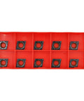 Front view of ten CCMT carbide turning inserts in a red plastic organizer tray