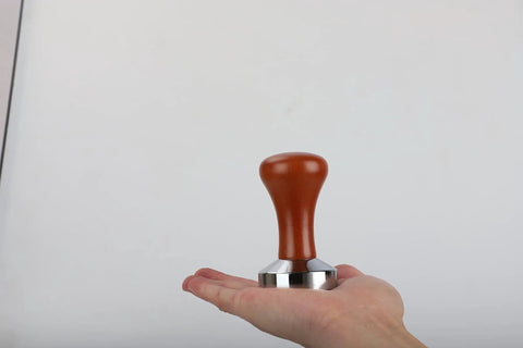 51mm Espresso Tamper With Stainless Steel Flat Base And Solid Wood Handle For 51mm Portafilters, held on a hand