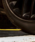 Close-up of tire crossing Weatherproof Garage Door Threshold Floor Seal 18 Foot Eight Inch Long Keeps Water Out Vermin Leaves And Debris.