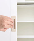 Hand installing 4 Pcs Self Stick Instant Cabinet Drawer Handles Adhesive No Drill Mounting Multipurpose Stick On Finger Pull on cabinet