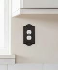 Meadows Greek Revival Light Switch Cover Plate And Wall Outlet Cover with decorative border, installed on wall near kitchen counter.