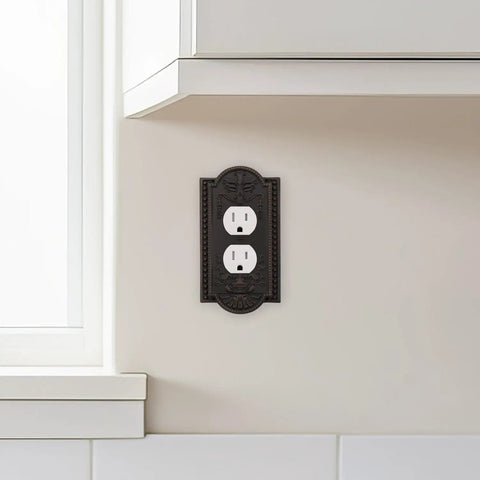 Meadows Greek Revival Light Switch Cover Plate And Wall Outlet Cover with decorative border, installed on wall near kitchen counter.