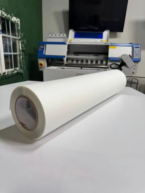 DTF Transfer Film Roll Hot Peel 24x328ft Clear PET Heat Transfer Paper, roll positioned on table in printing setup