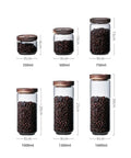 Top Shelf Airtight Glass Storage Jars With Smooth Acacia Wood Lids Keeps Your Daily Drip Locked Up Tight For Coffee Beans Tea And Dry Goods In This Bpa Free Four Pack Kitchen Essential, various sizes with beans.