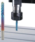 Installed blue-coated nano end mill router bit with 1/8in shank in CNC spindle; two bits visible.