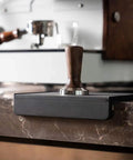 Espresso Tamping Mat For Baristas Grippy Black Food Grade Silicone Pad on countertop with portafilter mat.