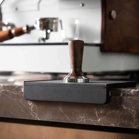 Espresso Tamping Mat For Baristas Grippy Black Food Grade Silicone Pad on countertop with portafilter mat.