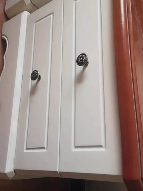 White cabinets with flower shape metal pull knobs in bronze tone for cabinets and drawers, 4 pack with screws, 1 inch by 1.4 inch, easy install