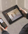 Micro Laser Distance Meter With Bluetooth Sync And Tilt Sensor in use, paired with tablet showing measurement data.