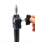 Close-up of black plastic 1/4-inch wing knob with brass insert being threaded into a metal clamp on a woodworking jig