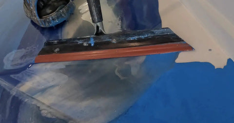 Metallic Colored Epoxies 18 Inch Epoxy Trowel Spreader Tool applying resin on blue floor surface