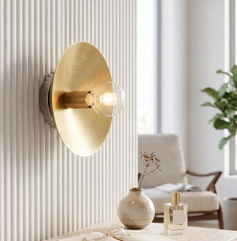 NautiGlow Modern Brass Brushed Wall Sconce with Round Backplate, Exposed Globe Light Fixture for Bedroom, Living Room, Hallway & Entryway mounted on textured wall.