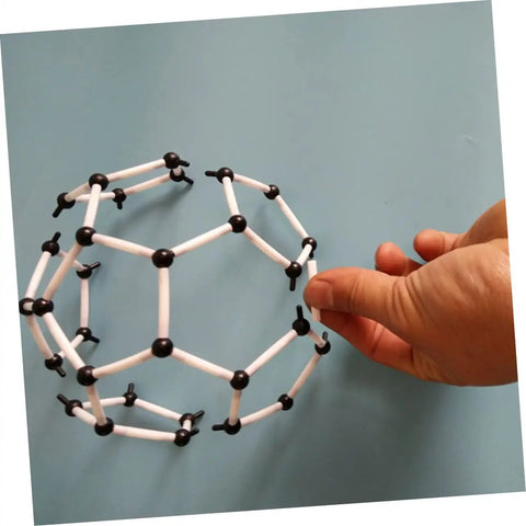 Hand holding C60 Molecule Model Kit For Classroom Learning And Teaching Aid Hands On Chemistry Set structure model against blue background