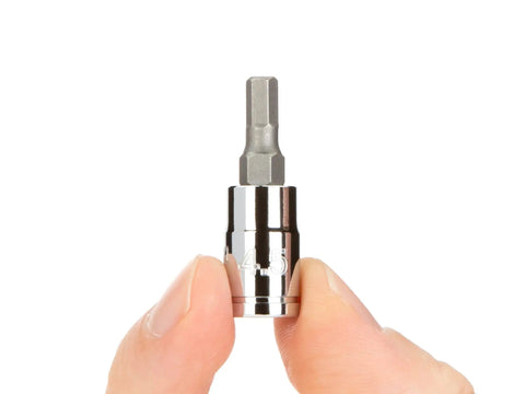 Fingers holding a hex bit socket from One Quarter Inch Drive Socket Set With Case Including Hex Torx Phillips Slotted Square Bits 42 Piece DIY Auto Tool Kit For Home Repairs And Mechanical Projects And Great For Automotive And Home Repair Enthusiasts.