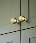 Soft Champagne Bronze Cabinet Knobs 12 Pack 1-3/16 Inch Round Zinc Alloy Hardware on green cabinet doors