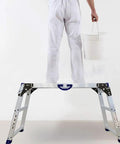 Person standing on All In One Work Platform 39 By 12 Inch, 50 Gear Height Adjustable Aluminum Step Ladder 25 To 35 Inches holding a bucket