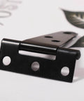 Close-up of black hinge resembling 2 Pcs Galvanized T Shaped Gate Hinges, Rust Resistant, 2 Inch Heavy Duty T Strap Hinges for outdoor use.