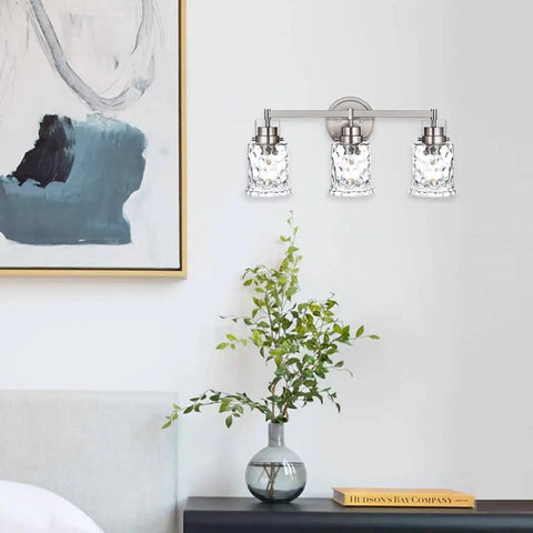 Three Light Vanity Light Over Mirror In Brushed Nickel Finish With Hammered Glass Shade Modern Metal Wall Sconce For Bathroom Hallway Or Makeup Table The Go-To Lighting Fixture mounted on a wall