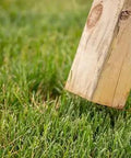 Wooden swing set leg positioned on grass, illustrating use with Playset Anchor Kit For Swing Sets Heavy Duty Ground Anchors That Keep Your Set Rock Solid Stationary And Safer For Outdoor Fun Easy Install Swing Set Hardware To Secure Play Equipment And Protect Your Kids.