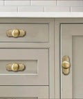 10 Pack 1-1/4 Inch Cabinet Knobs with 2.8-Inch Backplates Satin Gold Brushed Brass Drawer Knobs on light gray cabinet.