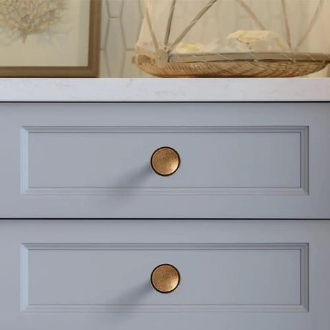 Round Knobs 1 Inch Solid Zinc Alloy Antique Brass Cabinet Handles on grey drawers, 4 pack, vintage kitchen bath drawer pulls.