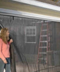Woman demonstrating Durable 14 Ft By 7 Ft Garage Screen With Easy Pass Through Zippered Access Storage Kit Included No Hassle Setup on garage