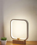 Cozy Minimalist Square Bedside Lamp With 3 Color Temperatures And Dimmable LED Lighting A Perfect Night Light For Bedroom Or Living Room Aluminum Accent Table Lamp For Office And Vibe Worthy Home Decor Gift on wooden base, illuminated.