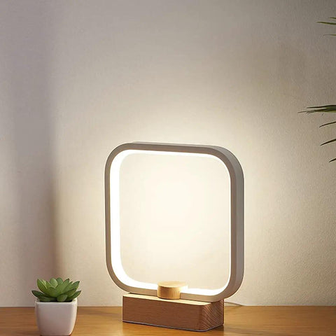 Cozy Minimalist Square Bedside Lamp With 3 Color Temperatures And Dimmable LED Lighting A Perfect Night Light For Bedroom Or Living Room Aluminum Accent Table Lamp For Office And Vibe Worthy Home Decor Gift on wooden base, illuminated.