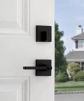 Matte Black Keyed Entry Lever And Deadbolt Combo With SmartKey For Easy Lockup on white door, view from inside with house outside