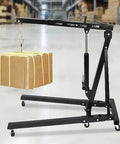 Badass Heavy Duty Folding Engine Hoist 2 Ton Hydraulic Cherry Picker with a box suspended, showcasing its durable carbon steel structure.