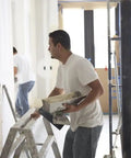 Worker using 18Lb EZ Sand 45 Joint Compound for drywall and painting projects, applying sandable gypsum formula for smooth finish.