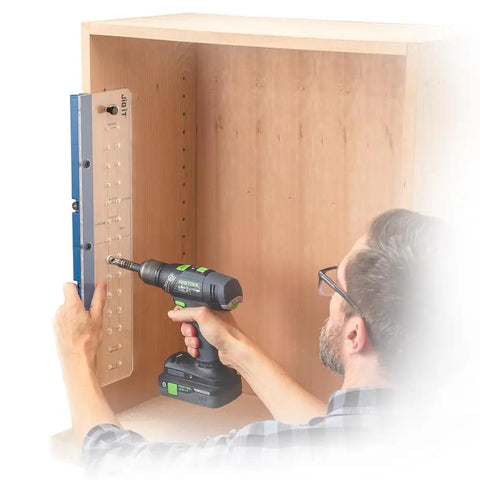 Man using Shelf Pin Drilling Jig For Cabinets And Woodworking With 1/4 Inch And 5mm Self Centering Bits inside a wooden cabinet