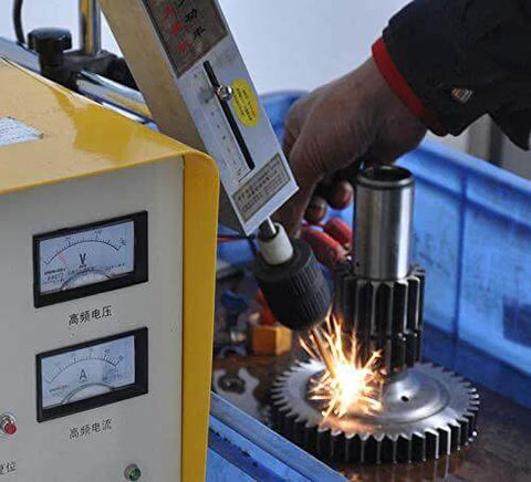 Front view of SFX EDM-8C 800W tap burner; yellow control panel with gauges as sparks fly while a tool works on a gear.