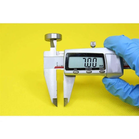Digital caliper measuring 7mm with blue-gloved hand, ideal for precision assessment of Heavy Duty 607 Hybrid Ceramic Ball Bearings.