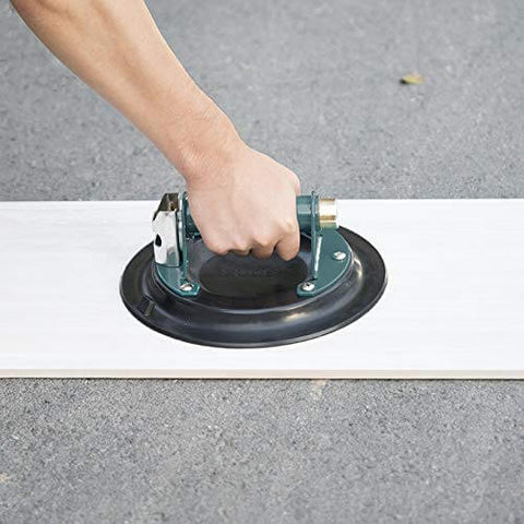 Hand using 8 Inch Glass Vacuum Suction Cup With Metal Handle And Brass Pump, lifting flat surface, heavy duty vacuum lifter