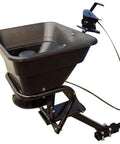 Hitch Mount Grass Seed Spreader With Rain Protector For ATV UTV Or Utility Tractor 12 Foot Broadcast Width 12 Volt Electric Spreader Built Beefy For Lawn And Garden Fertilizer And Seed Application viewed from side, black material, attached spreading mechanism.