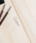 Stainless Steel Cotter Pins That Don't Loose Up: R Shape Fasteners With Wavy Design For Heavy Duty Mechanical Assembly And Industrial Hitch Stability on a wooden surface.