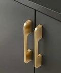 Close-up of Five Pack Solid Brushed Gold Cabinet Handles for kitchen cabinets, dressers and furniture, mounted on gray doors.