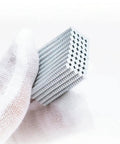 Stack of Tiny Neodymium Disc Magnets 2mm Diameter By 1mm Thick Nickel Coated Rare Earth Magnets, 0.06kg Pull, Pack Of 100 held by cloth.